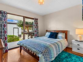 A bedroom with a bed and a window at Mangawhai Heads in Mangawhai