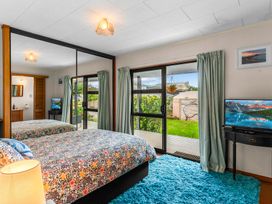 A bedroom with a bed and television at Mangawhai Heads in Mangawhai