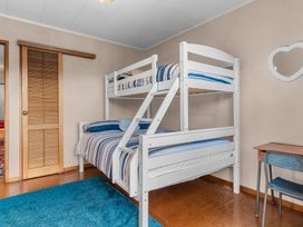A bedroom with a bunk bed and a desk at Mangawhai Heads in Mangawhai