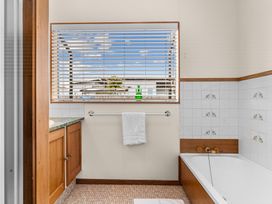 A bathroom with a bathtub and a towel at Mangawhai Heads in Mangawhai