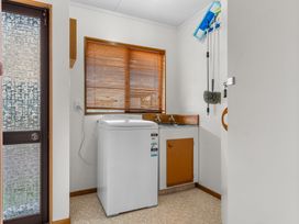 A laundry room with a washing machine and sink at Mangawhai Heads in Mangawhai