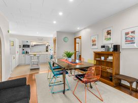 A dining room with a table and chairs at Mangawhai Heads in Mangawhai