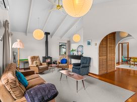 A living room with a sofa and chairs at Mangawhai Heads in Mangawhai