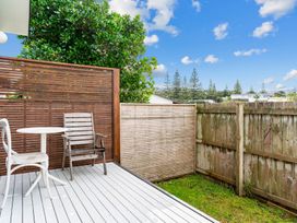 An outdoor space with a table and chairs at Mangawhai Heads in Mangawhai