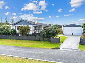 A house with a garage and trees at Mangawhai Heads