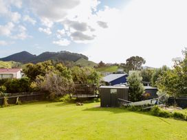 An outdoor view of a yard with a shed and a trampoline at Whiritoa Holiday House in Whiritoa