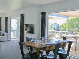 A dining room with a table and chairs at Whiritoa Holiday House in Whiritoa