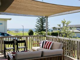 A seating area with a view of the ocean at Whiritoa Holiday House in Whiritoa