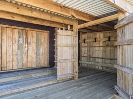 An outdoor shelter with wooden walls and a door at Railside Chalet - Raurimu Holiday Home National Park