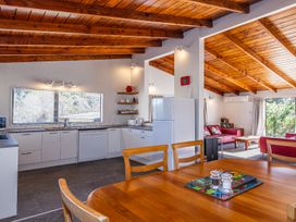 A kitchen area with a dining table and chairs at Railside Chalet - Raurimu Holiday Home National Park