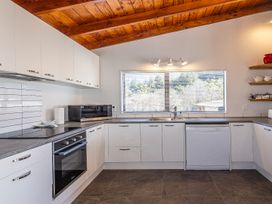 A kitchen with cabinets, sink, microwave and oven at Railside Chalet - Raurimu Holiday Home National Park