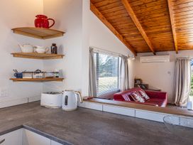 A kitchen with shelves and a red kettle at Railside Chalet - Raurimu Holiday Home, National Park