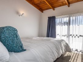 A bedroom with a bed and window at Railside Chalet - Raurimu Holiday Home National Park