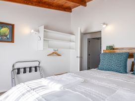 A bedroom with a bed and shelves at Railside Chalet - Raurimu Holiday Home National Park
