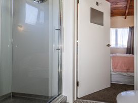 A bathroom featuring a shower and a door leading to a bedroom at Railside Chalet - Raurimu Holiday Home National Park