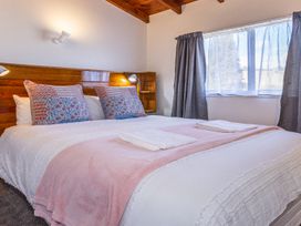 A bedroom with a bed and a window at Railside Chalet - Raurimu Holiday Home National Park
