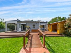 A house with a deck and shed in the garden at a property