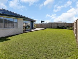 A garden with grass and a swing at Serendipity at One Tree Point - Whang?rei Holiday Home