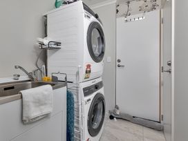 A laundry room with a washing machine and dryer at Serendipity at One Tree Point - Whang?rei Holiday Home