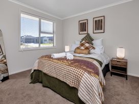 A bedroom with a bed and bedside table at Serendipity at One Tree Point - Whang?rei Holiday Home