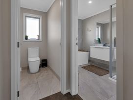 A bathroom featuring a toilet, sink, and bathtub at Serendipity at One Tree Point - Whang?rei Holiday Home