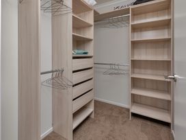 A closet with shelves and hangers at Serendipity at One Tree Point - Whang?rei Holiday Home