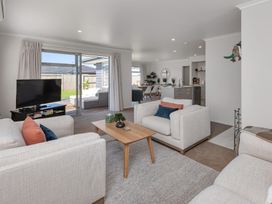 A living room with a sofa and coffee table at Serendipity at One Tree Point - Whang?rei Holiday Home
