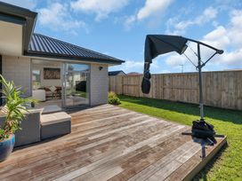 An outdoor area with a deck and furniture at Serendipity at One Tree Point - Whang?rei Holiday Home