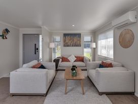 A living room with couches and a coffee table at Serendipity at One Tree Point - Whang?rei Holiday Home