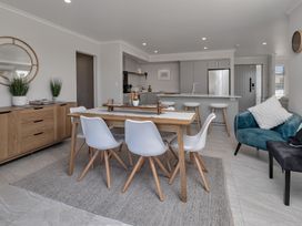 A dining room with a table and chairs at Serendipity at One Tree Point - Whang?rei Holiday Home