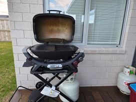 A barbecue grill and gas cylinders in an outdoor area at Serendipity - One Tree Point Holiday Home, One Tree Point