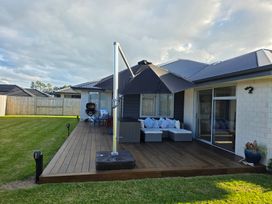A patio with seating and a grill at Serendipity - One Tree Point Holiday Home One Tree Point