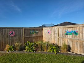 A garden area with a wooden fence and decorative art at Serendipity - One Tree Point Holiday Home One Tree Point