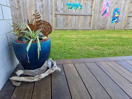 A garden with a blue planter and decorative art at Serendipity - One Tree Point Holiday Home One Tree Point