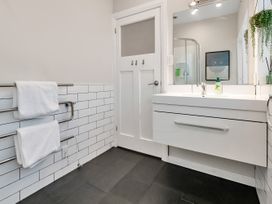 A bathroom with towels on a rack and a sink at Chic Whangarei Retreat - 10 min Walk to CBD, Whangarei