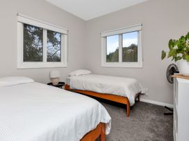 A bedroom with two beds and windows at Chic Whangarei Retreat - 10 min Walk to CBD in Whangarei