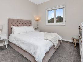 A bedroom with a bed and nightstand at Chic Whangarei Retreat - 10 min Walk to CBD, Whangarei