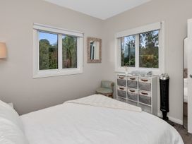 A bedroom with a bed and windows at Chic Whangarei Retreat - 10 min Walk to CBD in Whangarei