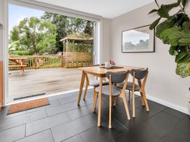 A dining room with a table and chairs leading to a deck at Chic Whangarei Retreat - 10 min Walk to CBD, Whangarei
