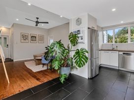 A kitchen with a refrigerator, sink, and potted plant at Chic Whangarei Retreat - 10 min Walk to CBD Whangarei