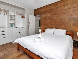 A bedroom with a bed and nightstand at Chic Whangarei Retreat - 10 min Walk to CBD, Whangarei