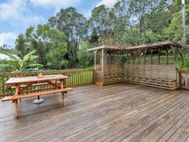 A wooden deck with a table and bench at Chic Whangarei Retreat - 10 min Walk to CBD, Whangarei