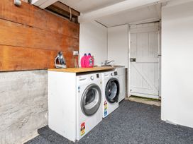 A laundry room with washer, dryer, and detergent bottles at Chic Whangarei Retreat - 10 min Walk to CBD, Whangarei