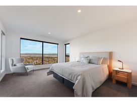 A bedroom with a bed and a chair at Horizon View Retreat - Nelson