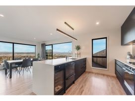 A kitchen with a dining area and large windows at Horizon View Retreat - Nelson Holiday Home