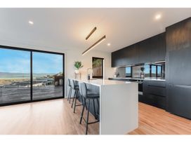 A kitchen with a central island and stools at Horizon View Retreat - Nelson