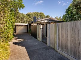 An outdoor area with a house, gate, and driveway at Living The Dream - Matarangi Holiday Home, Matarangi