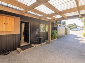 An outdoor area with a door and plants at Living The Dream - Matarangi Holiday Home Matarangi