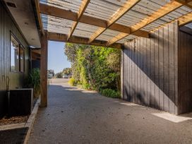 A carport leading to a driveway at Living The Dream - Matarangi Holiday Home in Matarangi