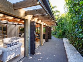 An outdoor area with seating and a pathway at Living The Dream - Matarangi Holiday Home, Matarangi